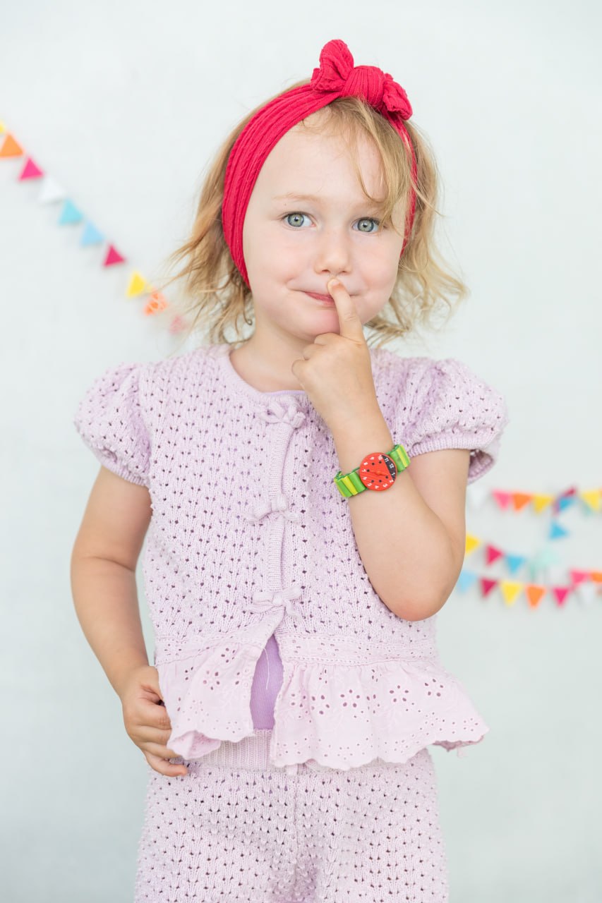 Kindergartenkind mit rotem Haarband vor einer bunten Wimpelkette