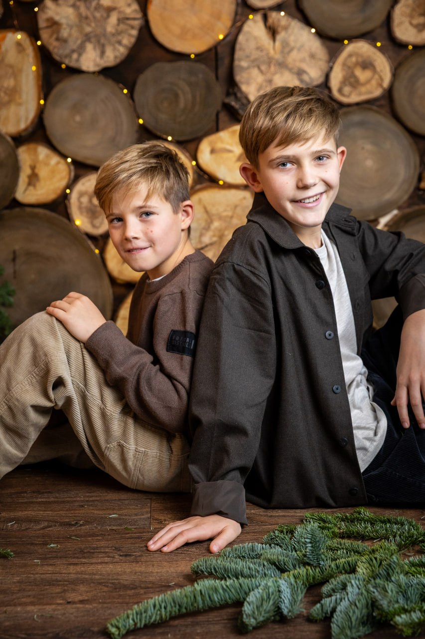 Zwei Jungen vor einer Holzwand mit Lichterkette