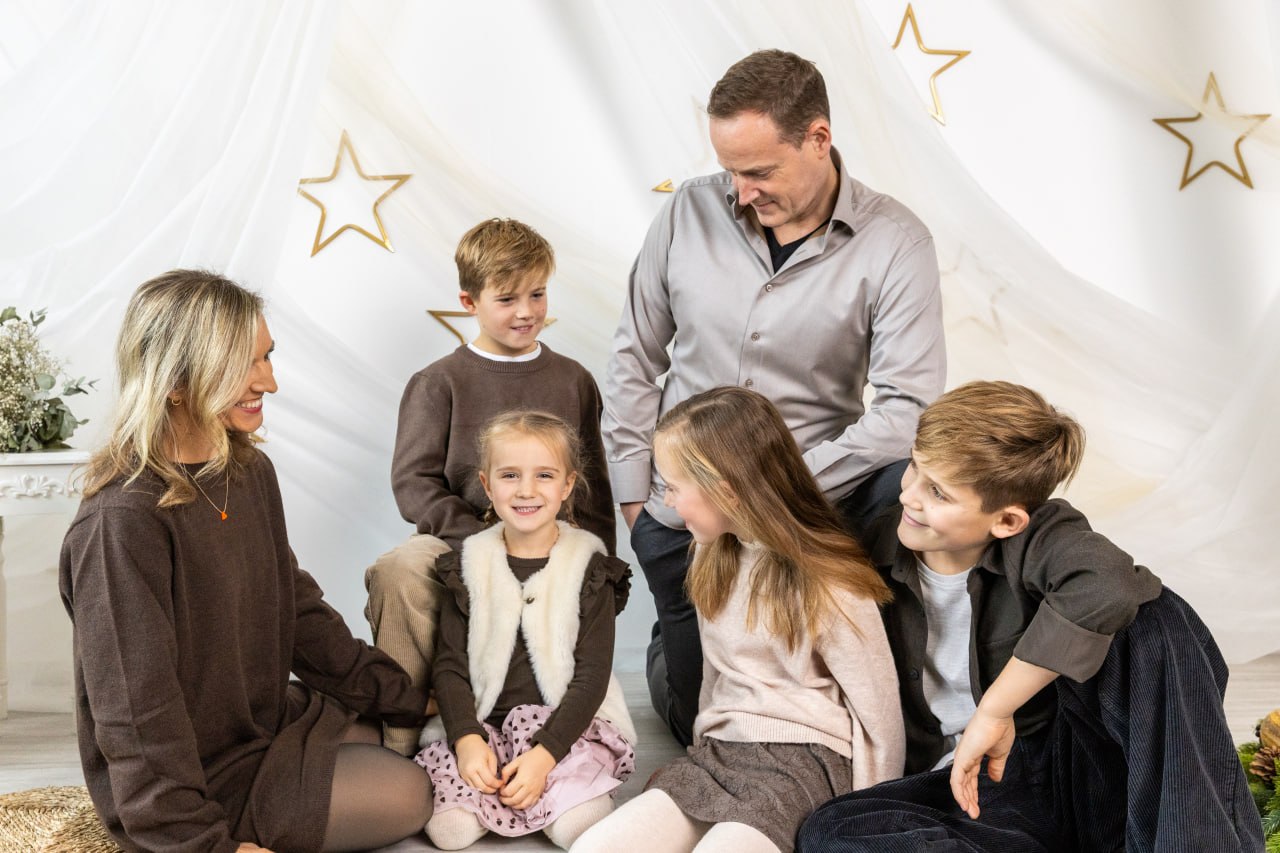 Familie im hellen Weihnachtsset mit goldenen Sternen