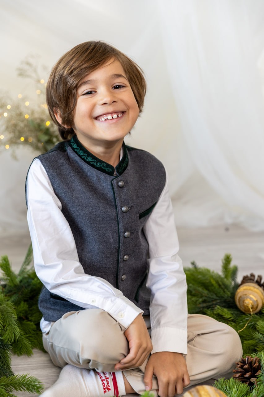 Junge im festlichen Outfit im hellen Weihnachtsset