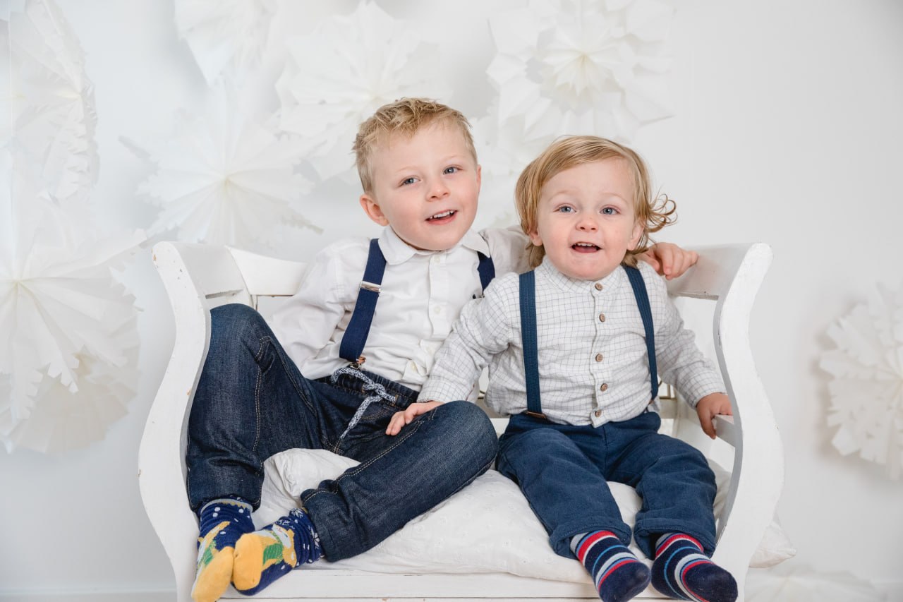 Zwei kleine Jungen im weißen Weihnachtsset mit Schneeflocken